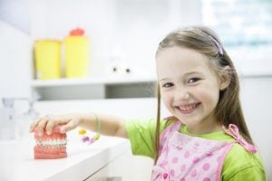 little girl in dentist looking at invisalign