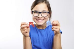 little girl holding retainer