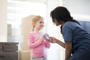 little girl getting a tooth brush from dental visit
