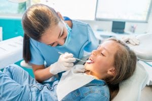pediatric dentist cleaning young girls teeth