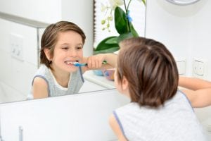 young child brushing teeth