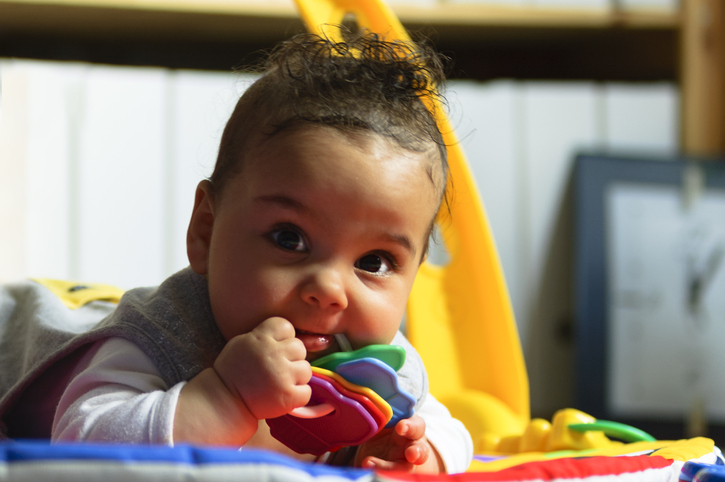 baby with toy in mouth 