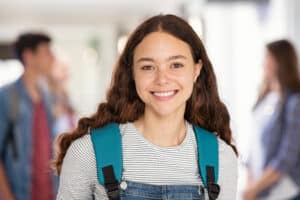 Portrait,Of,Beautiful,College,Student,Standing,In,Hallway,School,While