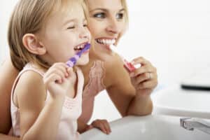 Mother,And,Daughter,Brushing,Teeth,Together
