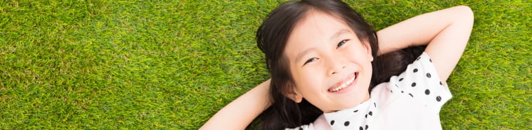 smiling child laying in the grass