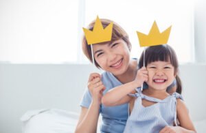 Beautiful funny girl mommy have crowns on sticks.