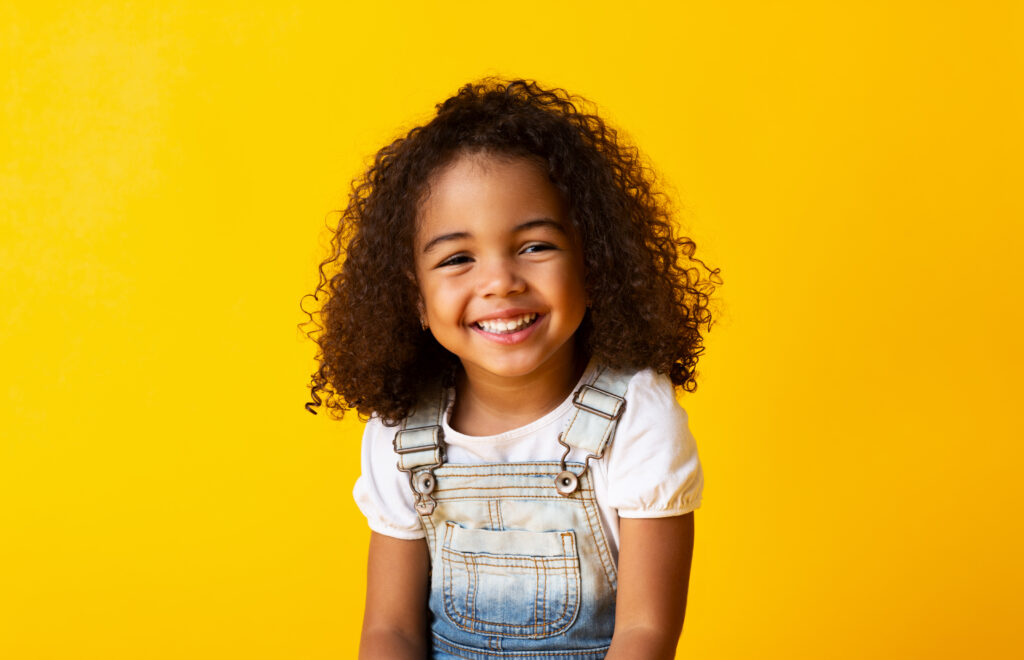 Happy,African american,Child,Girl,Smiling,To,Camera,Over,Yellow,Background
