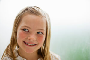 A child with braces on her teeth smiling