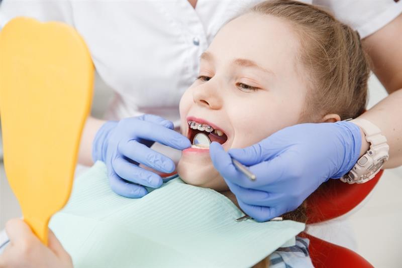 Child receiving pediatric dental exam and cleaning at dentist for preventive dental care